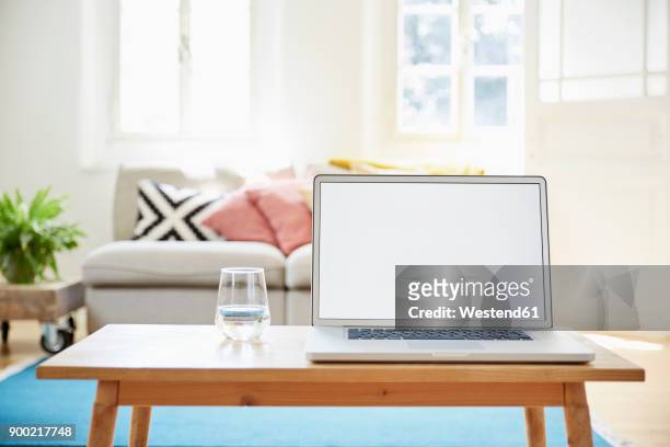 laptop on coffee table in a modern living room of an old country house - table basse photos et images de collection