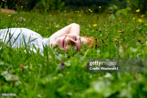 teenage girl relaxing on a meadow - im gras liegen stock-fotos und bilder