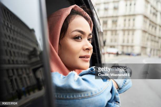uk, england, london, young woman wearing hijab looking out of a taxi - london taxi ストックフォトと画像