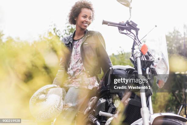 smiling young woman with her motorcycle - sports helmet stock pictures, royalty-free photos & images