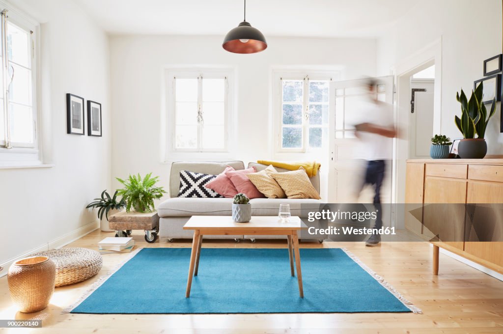 Man walking in bright modern living room in an old country house