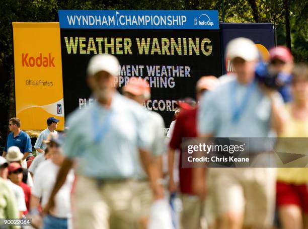 Fans leave the golf course for a weather delay during the third round of the Wyndham Championship at Sedgefield Country Club on August 22, 2009 in...