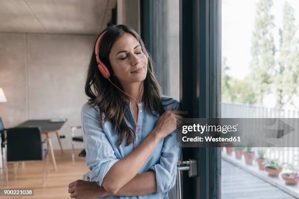 relaxed woman listening to music at home - headphones eyes closed stock pictures, royalty-free photos & images