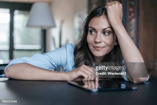woman with tablet leaning on table - brown hair stock pictures, royalty-free photos & images