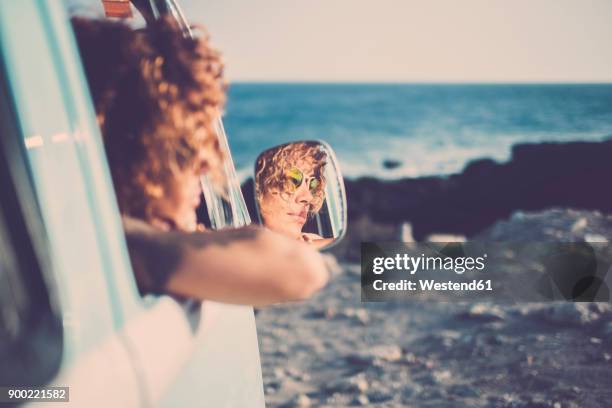 wing mirror with mirror image of woman looking out of a car - looking out car window stock pictures, royalty-free photos & images