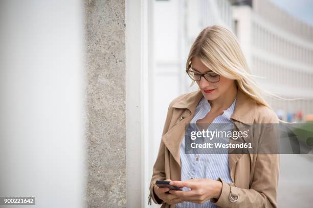 young businesswoman looking at cell phone - red blouse fotografías e imágenes de stock