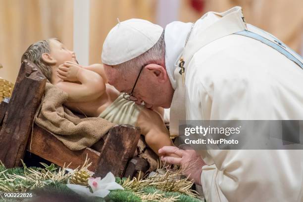 Pope Francis kisses a statue of the Divine Infant as he celebrates a new year's Mass in St. Peter's Basilica at the Vatican, Monday, Jan. 1, 2018.