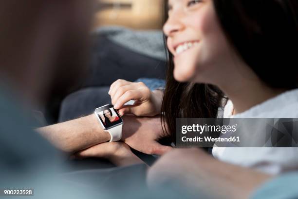 daughter and father with smartwatch with mother waving - international mother language day stock-fotos und bilder