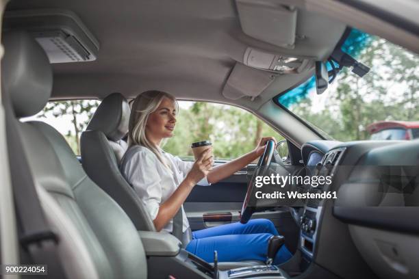 smiling businesswoman holding takeaway coffee driving car - sitting on top of car stock pictures, royalty-free photos & images