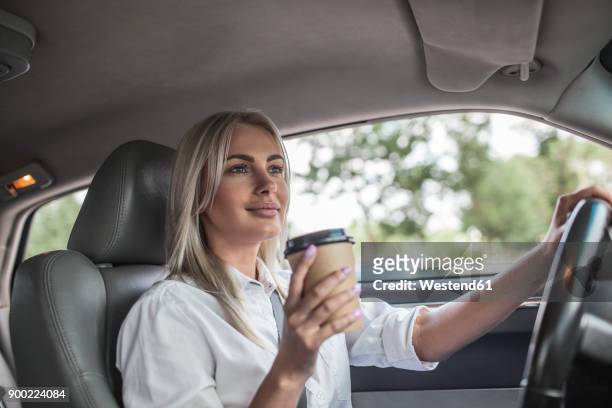 smiling businesswoman holding takeaway coffee driving car - young woman gray hair stock pictures, royalty-free photos & images