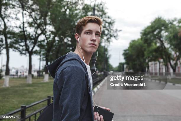 young man with cell phone and earphones in the city - 18 19 anni foto e immagini stock