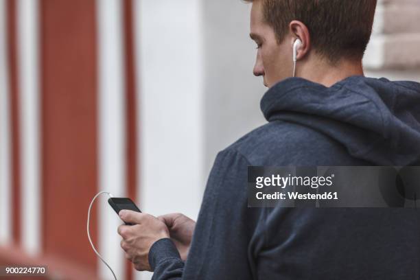 young man with cell phone and earphones - man and his hoodie imagens e fotografias de stock