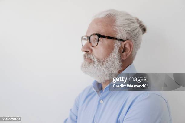 portrait of serious mature man with beard and glasses - man bun stock pictures, royalty-free photos & images