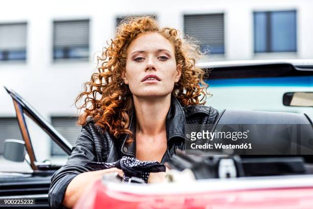 portrait of confident redheaded woman in sports car - car attitude stock pictures, royalty-free photos & images