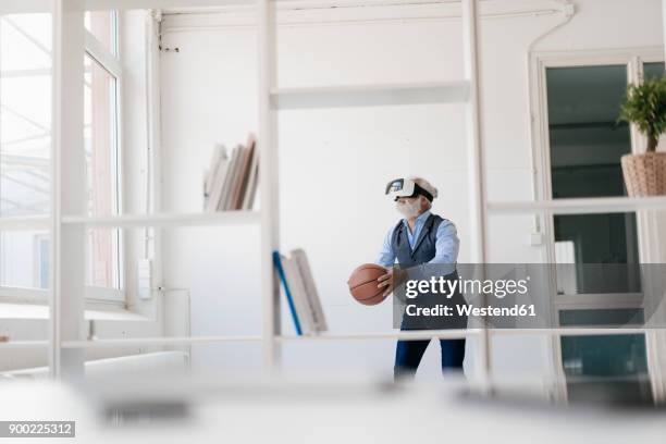 mature man wearing vr glasses playing basketball in office - digital techniques ストックフォトと画像