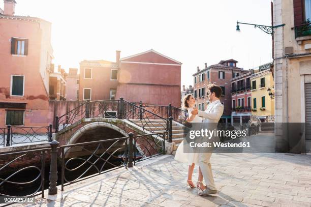 italy, venice, dancing bridal couple at sunrise - wedding dance stock-fotos und bilder