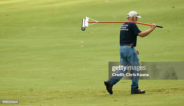 Grounds crew worker carries a squeegee after clearing standing water from the fairway during the third round of the Wyndham Championship at...