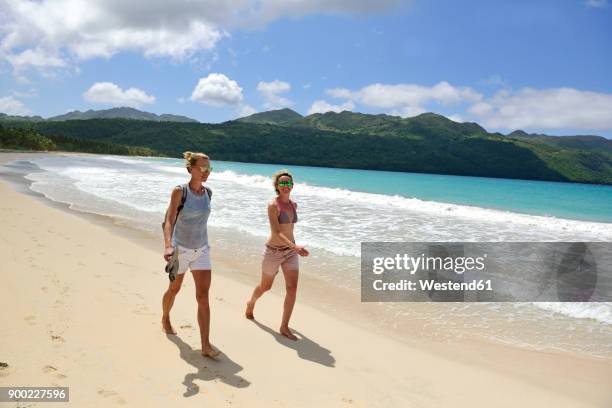 dominican republic, samana, two women walking on the beach - halbinsel samaná stock-fotos und bilder