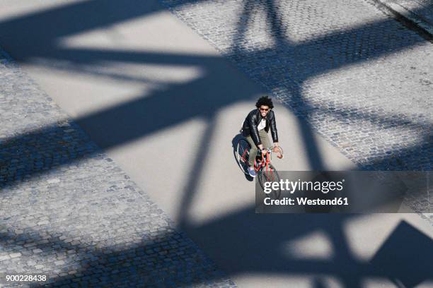 elevated view of smiling man with sunglasses riding bicycle - bicycle lane stock pictures, royalty-free photos & images