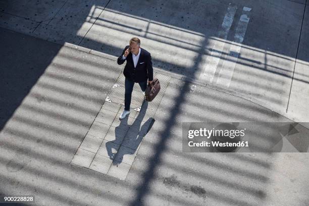 businessman on the phone walking on pavement, top view - maletín para portátil fotografías e imágenes de stock