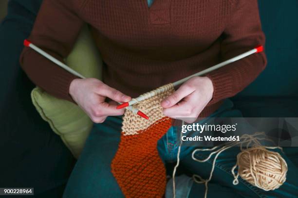 young man knitting a scarf, partial view - lavorare a maglia foto e immagini stock