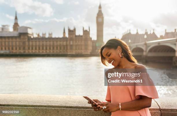 uk, london, woman sending messages with her smartphone near westminster bridge - person falls from westminster bridge stock-fotos und bilder