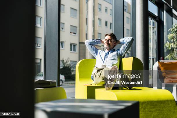 businessman relaxing in office lounge - hände hinter dem kopf stock-fotos und bilder