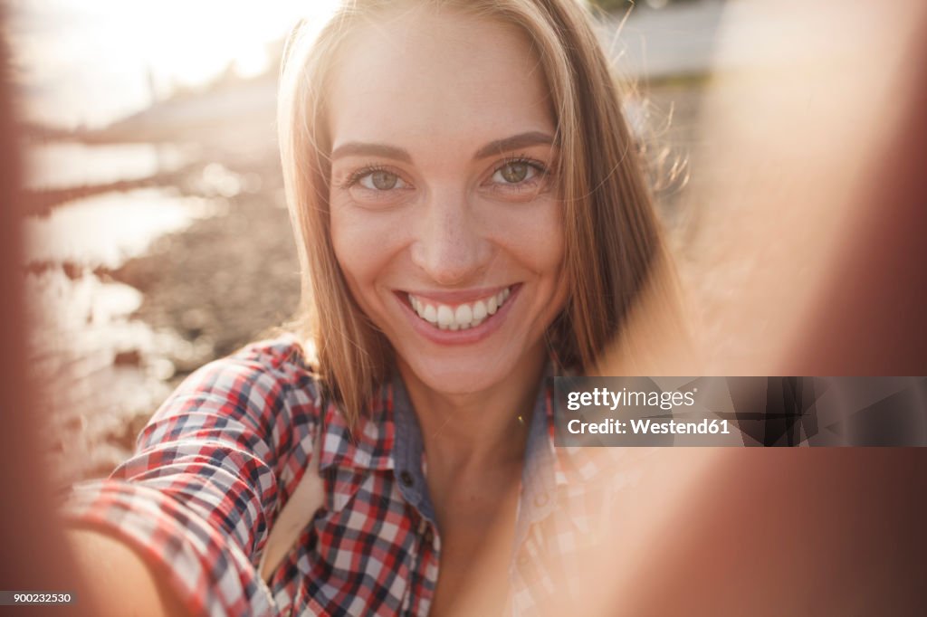 Portait of happy young woman at the riverside