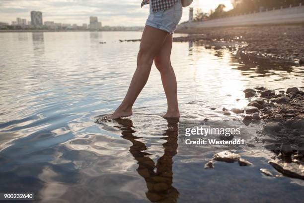 woman wading in a river at sunset - wading river stock pictures, royalty-free photos & images