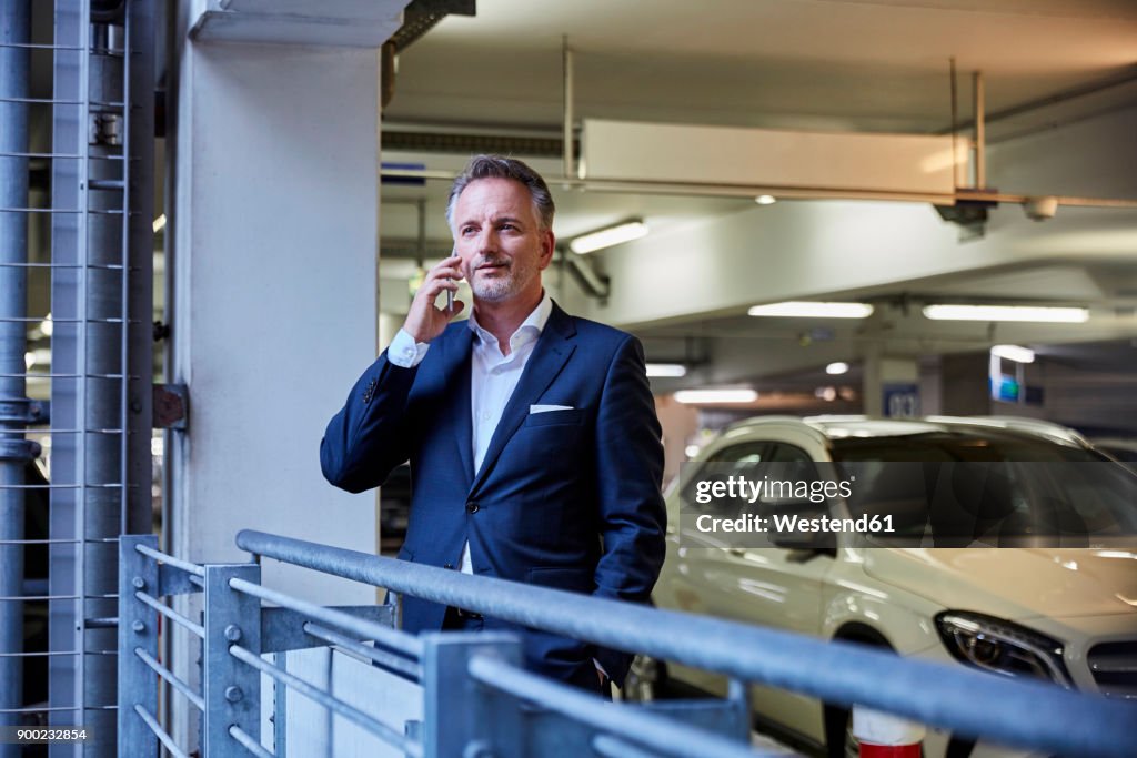 Businessman using smartphone in parking garage