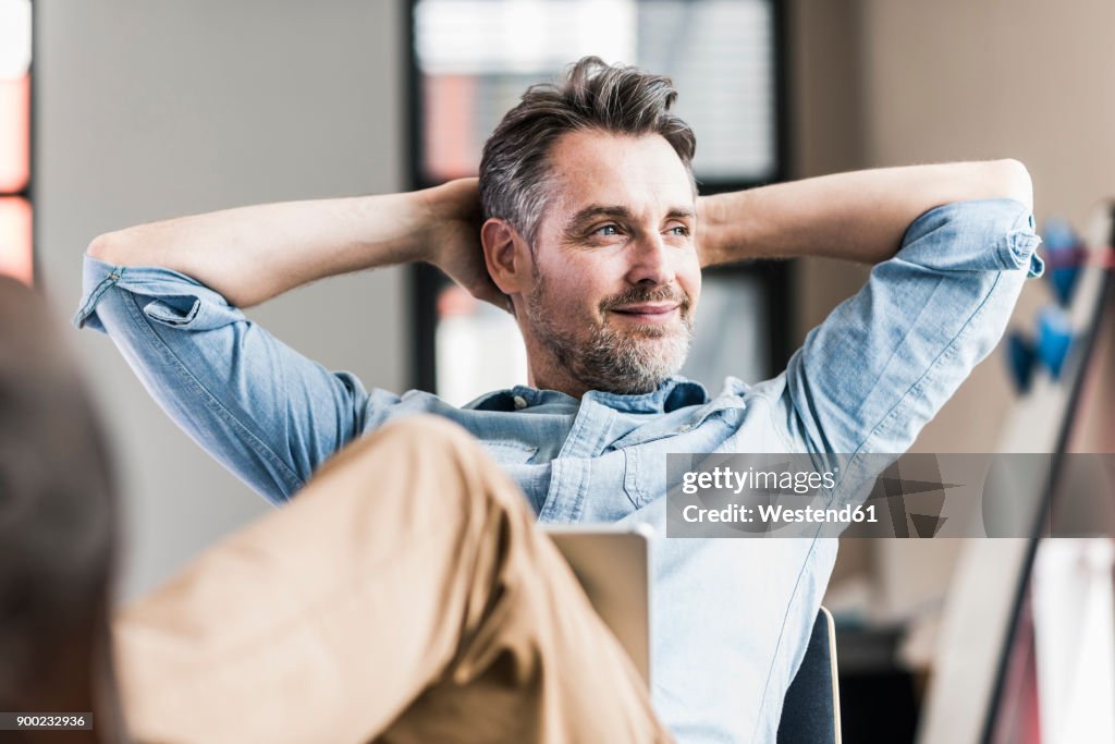 Businessman in office leaning back