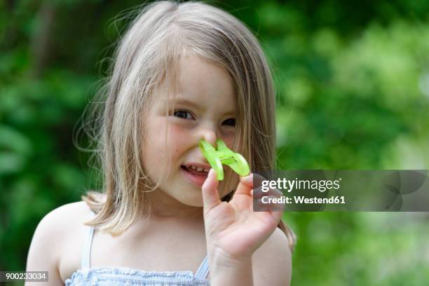 portrait of little girl with clothes peg on her nose - wäscheklammer stock-fotos und bilder