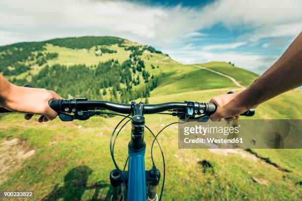 germany, bavaria, pfronten, mountainbiker riding downhill on alpine meadow near aggenstein - journey pov stockfoto's en -beelden
