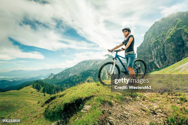 germany, bavaria, pfronten, woman with mountain bike on alpine meadow near aggenstein - meta turistica fotografías e imágenes de stock