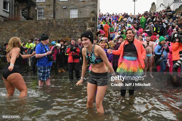 Members of the public react to the water as they join around 1100 New Year swimmers, many in costume, in front of the Forth Rail Bridge during the...