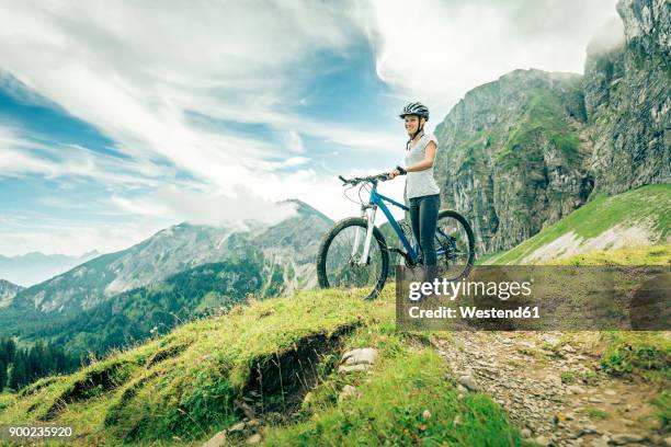 germany, bavaria, pfronten, smiling teenage girl with mountain bike on alpine meadow near aggenstein - bavaria girl stock pictures, royalty-free photos & images