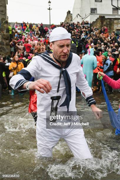 Members of the public react to the water as they join around 1100 New Year swimmers, many in costume, in front of the Forth Rail Bridge during the...