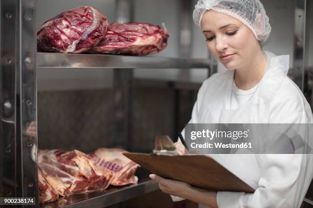 woman with clipboard in storehouse of a butchery - cold storage room stock pictures, royalty-free photos & images