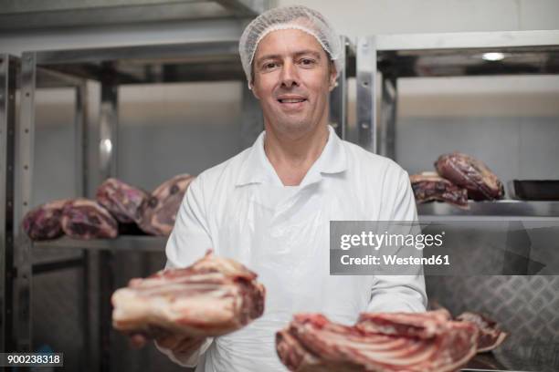 portrait of smiling butcher holding meat - butcher portrait imagens e fotografias de stock