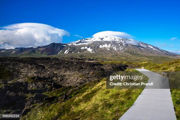 boardwalk through volcanic rock, djupalonssandur beach, mountain snaefellsjoekull snaefellsnes at back, iceland - snaefellsjokull stock pictures, royalty-free photos & images