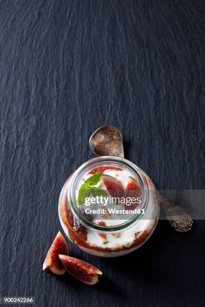 glass of mascarpone cream with fig compote and walnuts on slate - schist fotografías e imágenes de stock