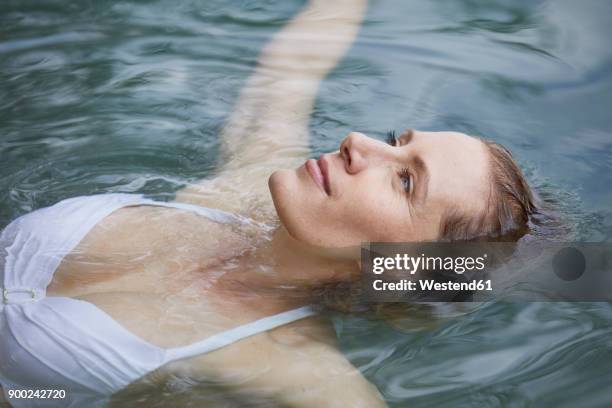 portrait of relaxed woman floating on water - beautiful mature woman stock pictures, royalty-free photos & images