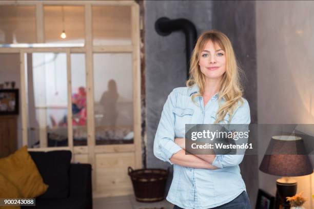 portrait of confident blond woman at home - denim shirt stock pictures, royalty-free photos & images