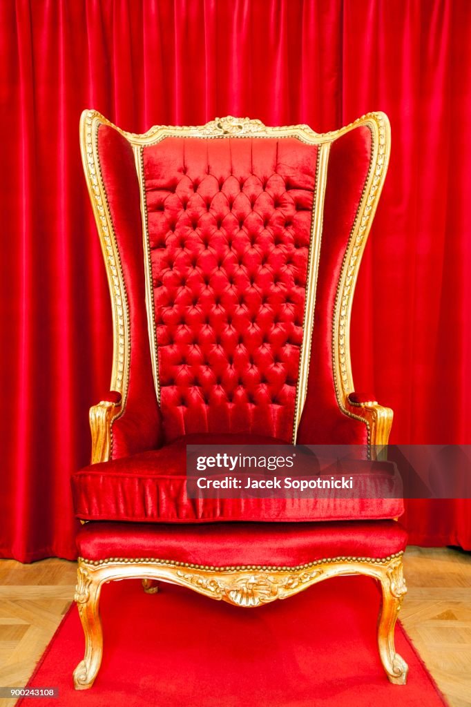 Red royal throne and red curtain behind