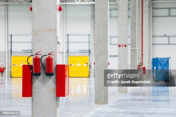 modern empty storehouse with fire extinguishers - fire prevention stock pictures, royalty-free photos & images