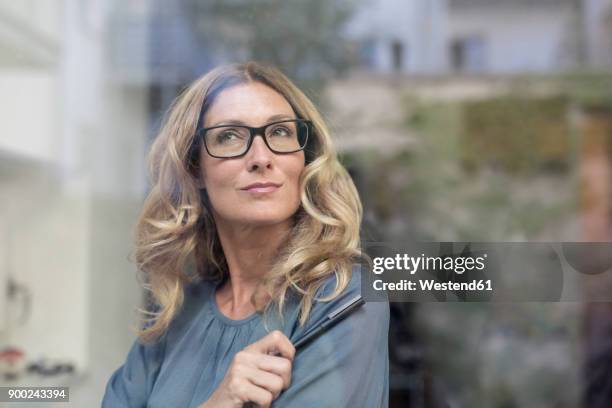 toughtful businesswoman behind windowpane - glass reflection in office stock pictures, royalty-free photos & images