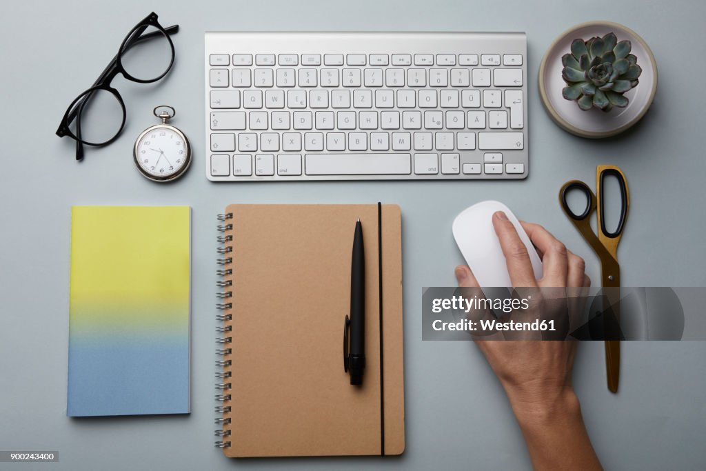 Top view of woman using computer mouse on desk