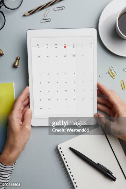top view of woman holding tablet with calendar on desk - calendar 2017 imagens e fotografias de stock