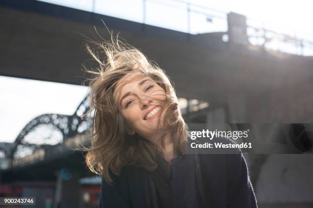 portrait of happy woman with blowing hair - tossing hair facing camera woman outdoors stock pictures, royalty-free photos & images