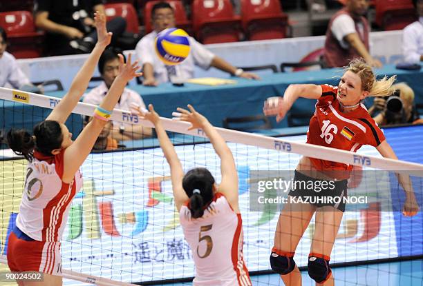 Germany's Margareta Kozuch spikes the ball against China's Wang Yimei and Chu Jinling during their final round match at the World Grand Prix women's...